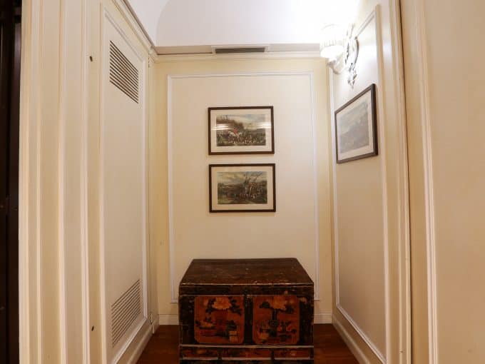 Elegante ingresso con pareti dipinte e decorazioni artistiche in stile classico.