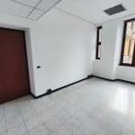 Vano ufficio vuoto con grandi finestre e pavimento in gres, ideale per uffici o studi professionali.