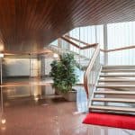 Ingresso spazioso con scale in legno e illuminazione naturale, ambiente elegante e accogliente.