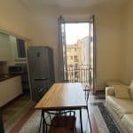 Ampia cucina soggiorno con balcone e luce naturale, arredato con stile moderno.