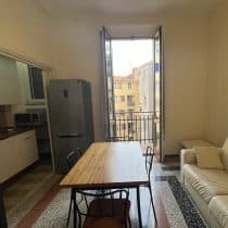 Ampia cucina soggiorno con balcone e luce naturale, arredato con stile moderno.