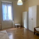 Ampio soggiorno con parquet in legno, grandi finestre e arredi bianchi, ideale per vivere in舒适e stile.