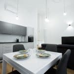 Appartamento moderno con soggiorno e cucina a vista, arredato con stile e illuminazione elegante.