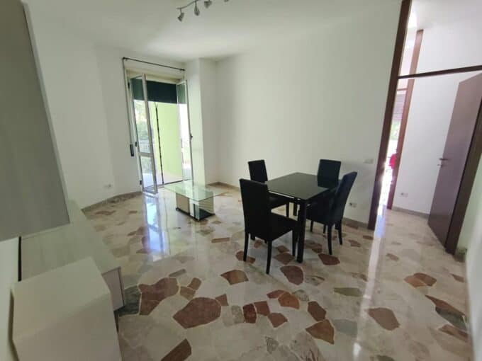 Interno di un bilocale arredato con soggiorno e zona pranzo luminosi.